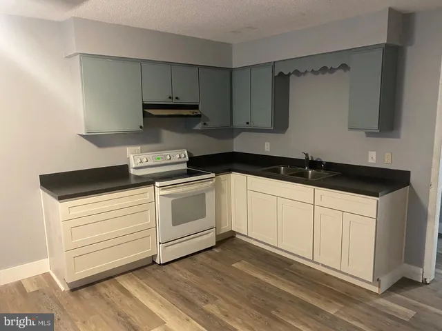 a white kitchen with sink and cabinets
