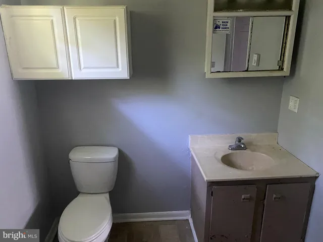 a bathroom with a toilet sink and mirror