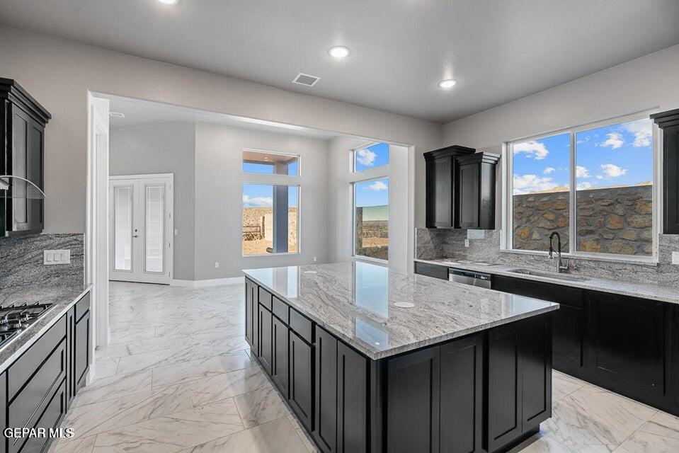 7353 Cimarron Rim Road El Paso, TX 79911 - Photo 10 of 30 a kitchen with center island table and chairs in it