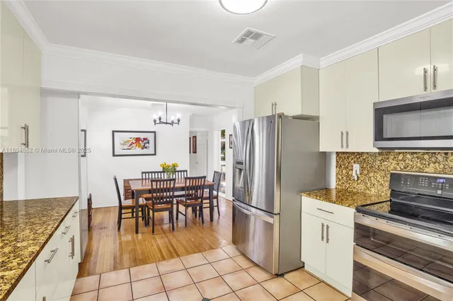 a kitchen with stainless steel appliances granite countertop a refrigerator and a stove top oven