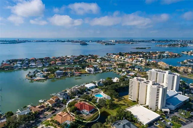 an aerial view of ocean and residential houses with outdoor space