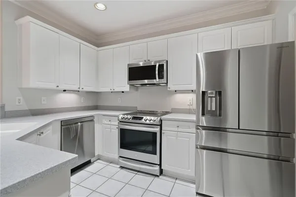 a kitchen with stainless steel appliances granite countertop a refrigerator and a stove top oven