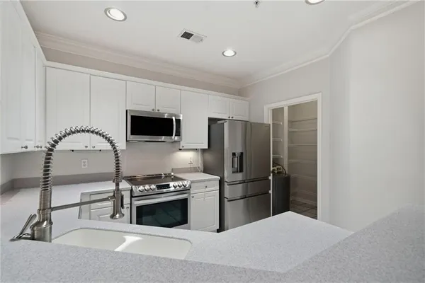 a kitchen with granite countertop a refrigerator and a stove top oven