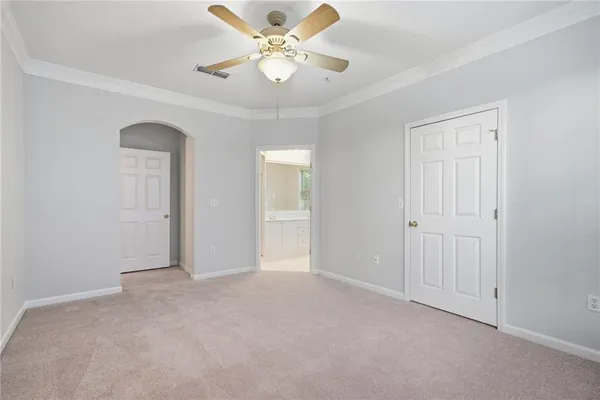 an empty room with fan and a chandelier fan