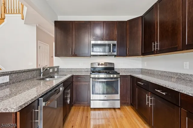 a kitchen with a sink stove top oven and microwave