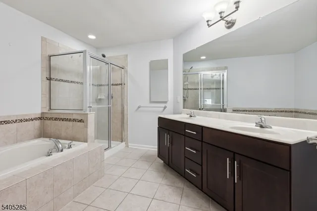 a bathroom with a tub sink shower and mirror