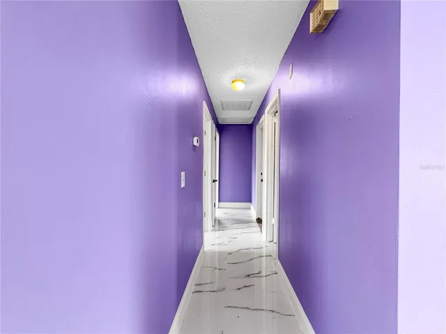 a view of empty room with wooden floor and ceiling fan