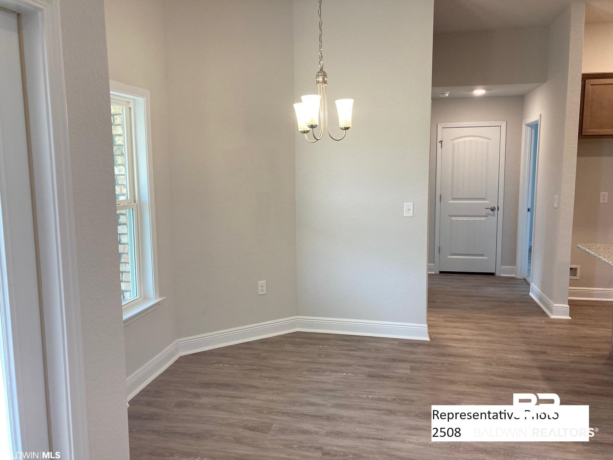 2201 Pollard Road Daphne, AL 36526 - Photo 8 of 15 Spare room with a wealth of natural light, a chandelier, and dark hardwood / wood-style floors