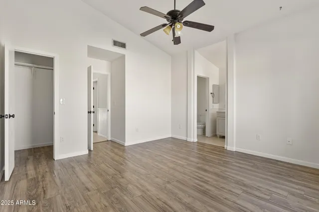 a view of a big room with wooden floor and hallway