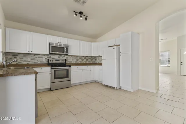 a kitchen with stainless steel appliances granite countertop a stove a sink and a refrigerator