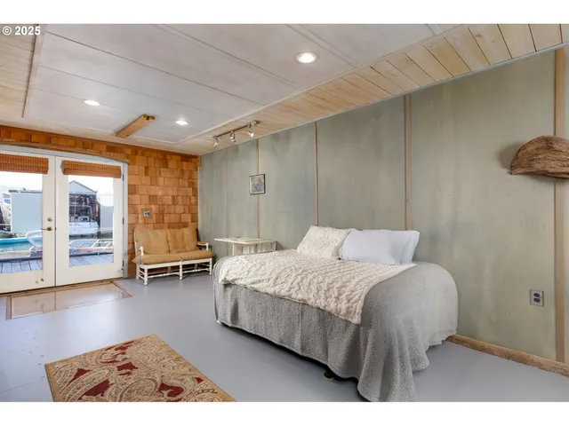 a bedroom with a bed a table and glass door