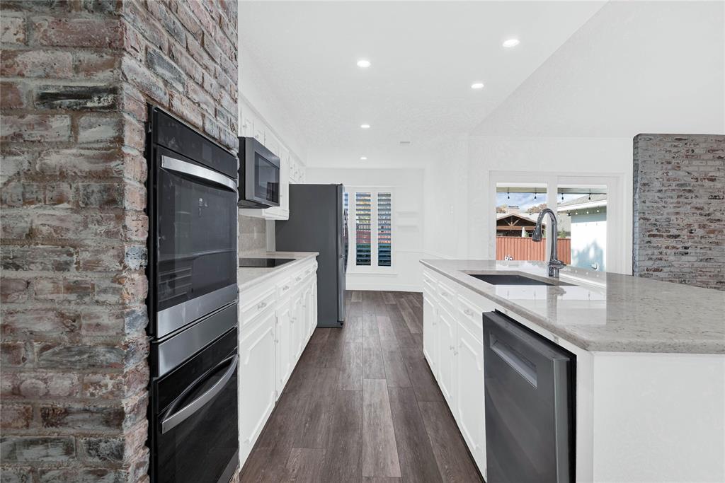 1104 West Lookout Drive Richardson, TX 75080 - Photo 11 of 40 a kitchen with stainless steel appliances granite countertop a lot of counter space and wooden floor