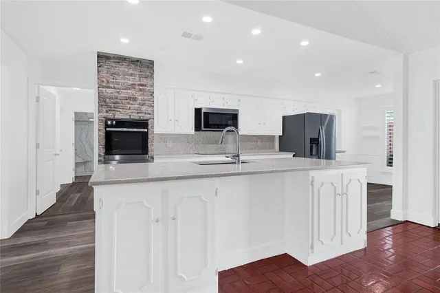 a kitchen with stainless steel appliances granite countertop a refrigerator and a stove top oven