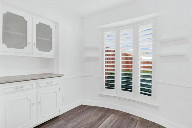 an empty room with windows and fireplace