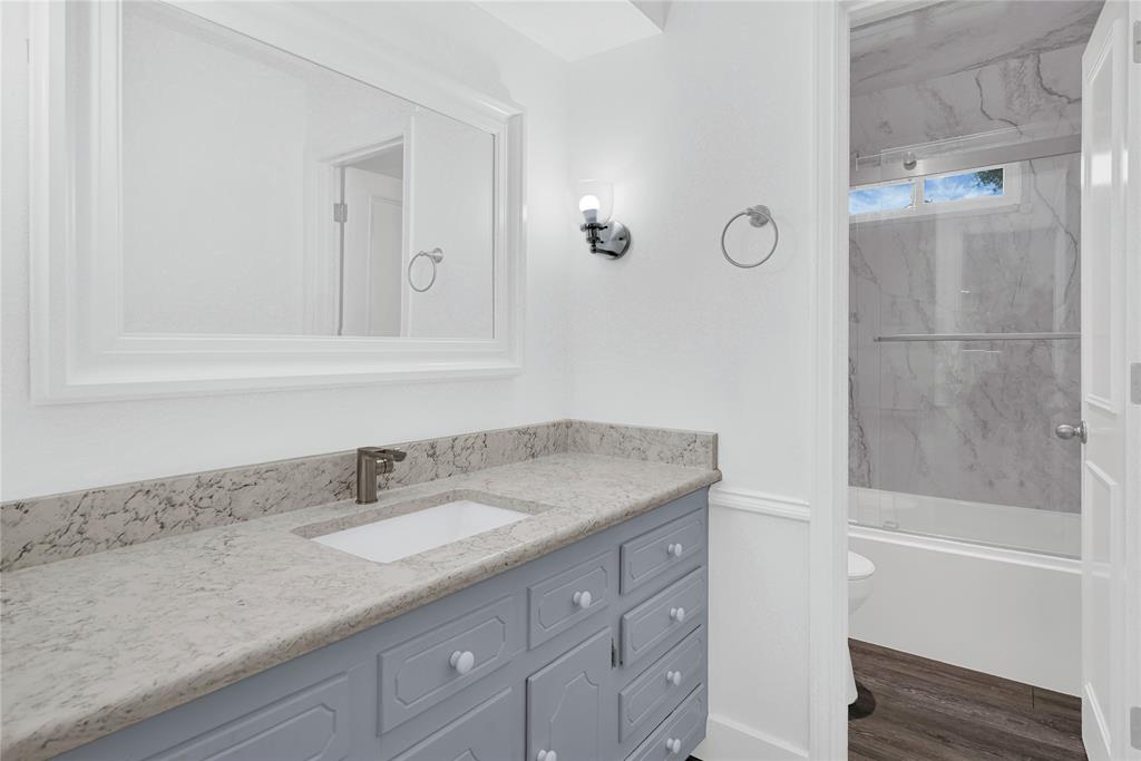 1104 West Lookout Drive Richardson, TX 75080 - Photo 29 of 40 a bathroom with a granite countertop sink a mirror and a bathtub