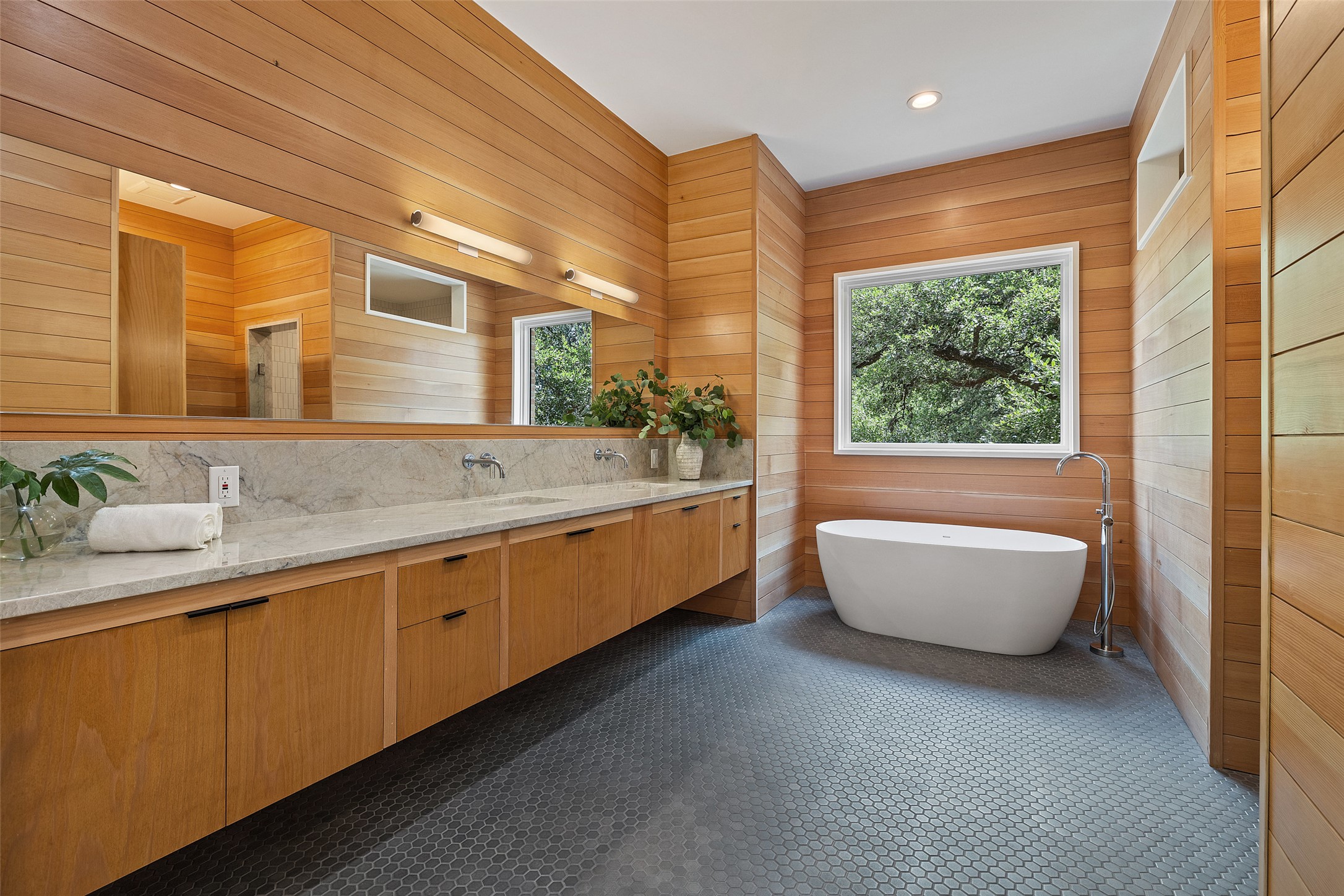 1319 Bonham Terrace Austin, TX 78704 - Photo 15 of 24 Bathroom with plenty of natural light, double vanity, a freestanding tub, wood walls, and dark tile patterned floors