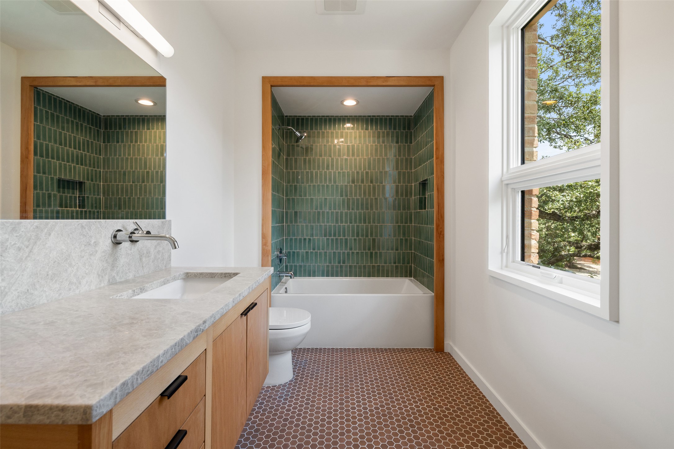 1319 Bonham Terrace Austin, TX 78704 - Photo 19 of 24 Bathroom featuring washtub / shower combination, vanity, and dark tile patterned flooring