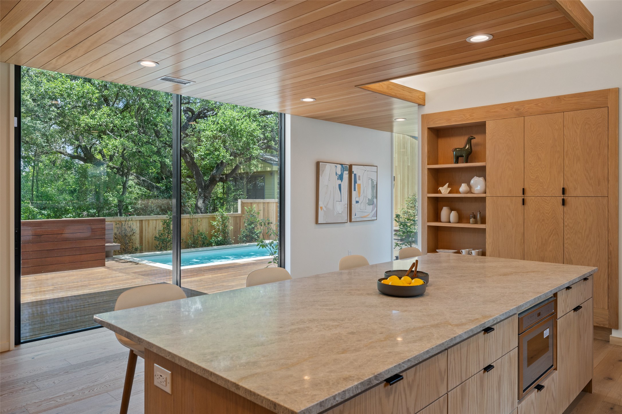 1319 Bonham Terrace Austin, TX 78704 - Photo 2 of 24 Kitchen with light brown cabinetry, light wood-style floors, a center island, modern cabinets, and wood ceiling