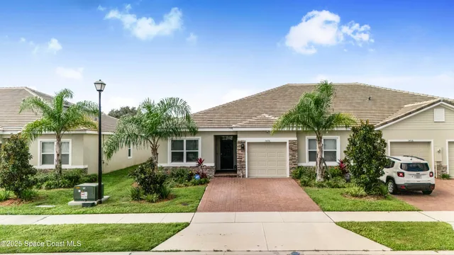 a front view of a house with a yard and potted plants