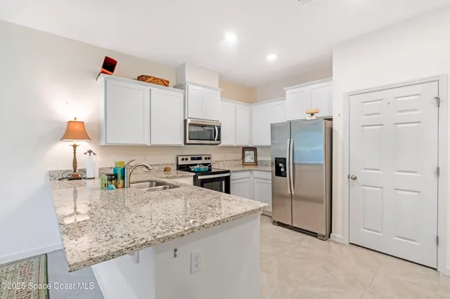 a kitchen with stainless steel appliances granite countertop a refrigerator sink and microwave