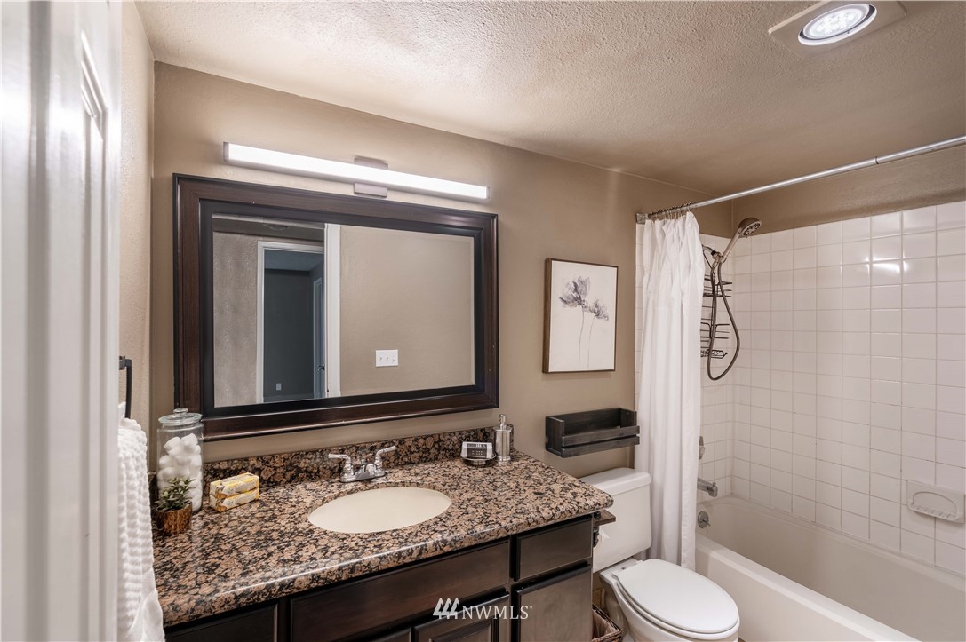 17537 151st Avenue Southeast, Unit 98 Renton, WA 98058 - Photo 13 of 19 a bathroom with a granite countertop sink toilet and shower
