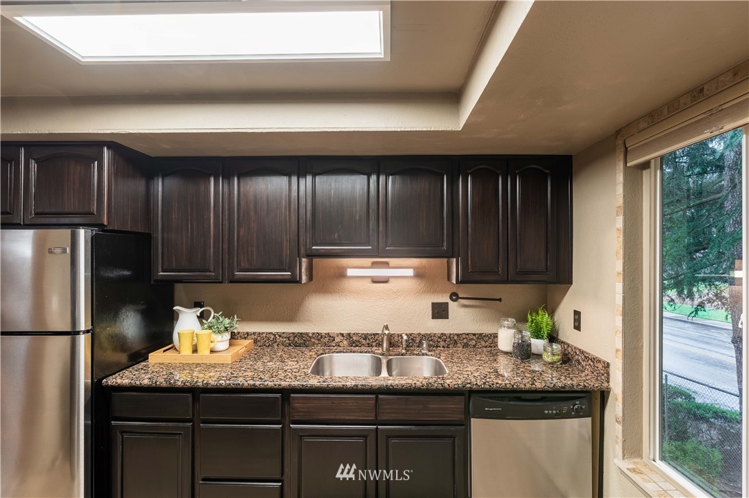 17537 151st Avenue Southeast, Unit 98 Renton, WA 98058 - Photo 8 of 19 a kitchen with granite countertop stainless steel appliances and wooden cabinets