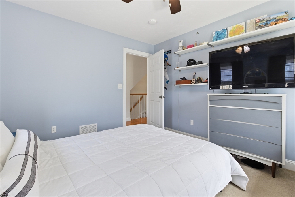 94 Progress Street, Unit 94 Abington, MA 02351 - Photo 19 of 35 a bedroom with a large bed and a flat tv screen on dresser