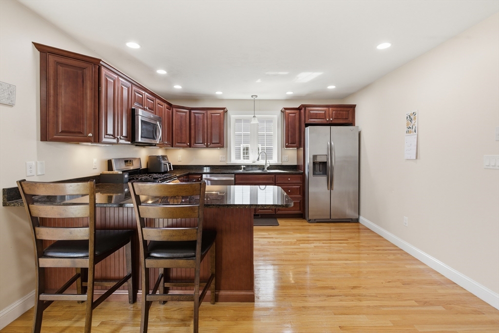 94 Progress Street, Unit 94 Abington, MA 02351 - Photo 7 of 35 a kitchen with stainless steel appliances granite countertop a refrigerator and a stove top oven