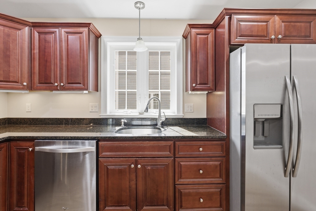 94 Progress Street, Unit 94 Abington, MA 02351 - Photo 8 of 35 a kitchen with granite countertop a refrigerator and a sink