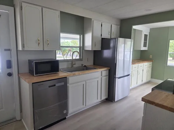 a kitchen with stainless steel appliances granite countertop a refrigerator a stove a sink and a microwave