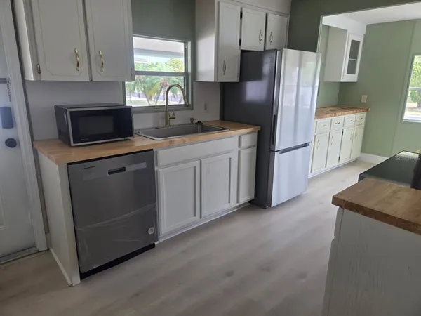 a kitchen with stainless steel appliances granite countertop a refrigerator a stove a sink and a microwave