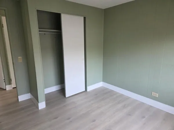 an empty room with wooden floor and closet