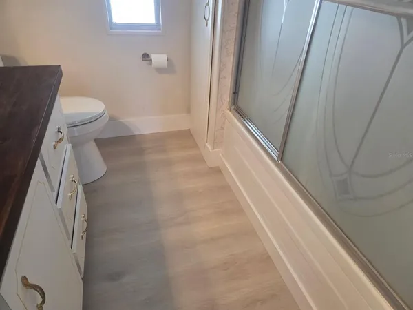 a bathroom with a granite countertop shower and a toilet