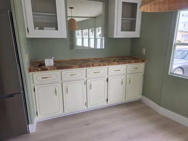 a kitchen with white cabinets and sink