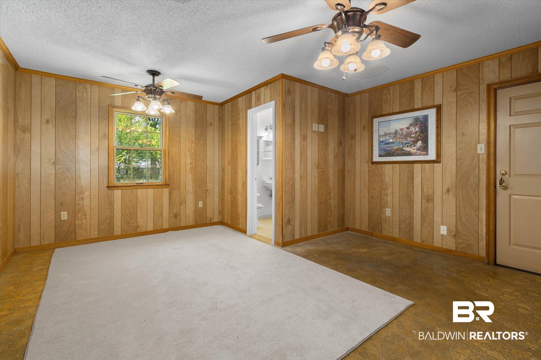 5503 Darring Street Satsuma, AL 36572 - Photo 23 of 31 Empty room with ceiling fan, a textured ceiling, ornamental molding, and wood walls