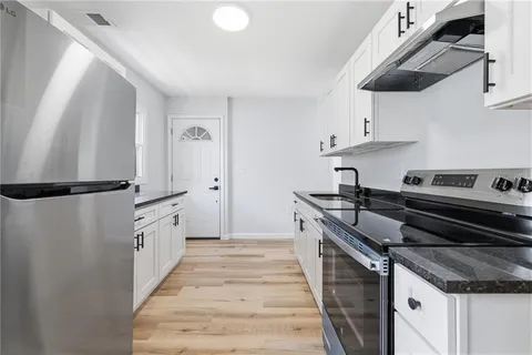 a kitchen with stainless steel appliances granite countertop a stove and a refrigerator