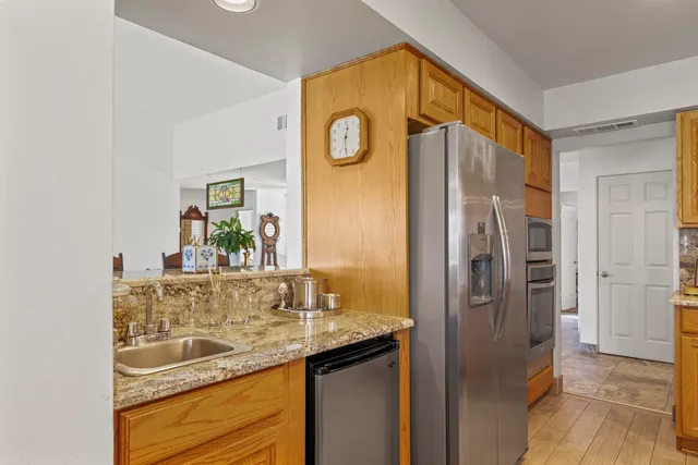 a kitchen with stainless steel appliances granite countertop a refrigerator and a stove