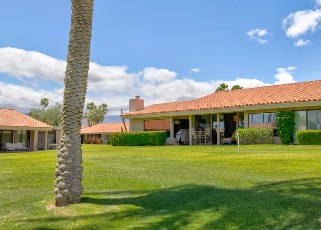 a view of a swimming pool with a table and chairs potted plants