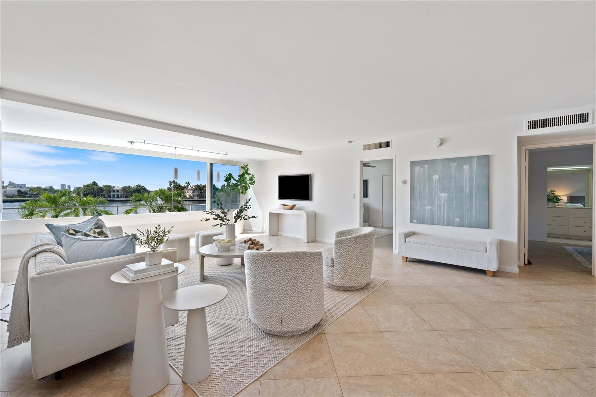 215 North Birch Road, Unit 2B Fort Lauderdale, FL 33304 - Photo 2 of 34 a living room with furniture a flat screen tv and a floor to ceiling window