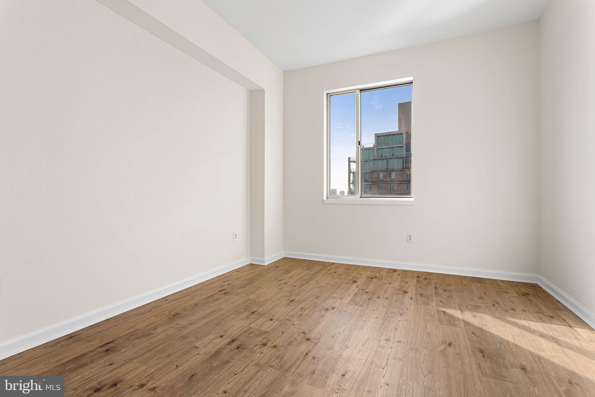 901 North Penn Street, Unit R2203 Philadelphia, PA 19123 - Photo 26 of 58 an empty room with wooden floor and windows