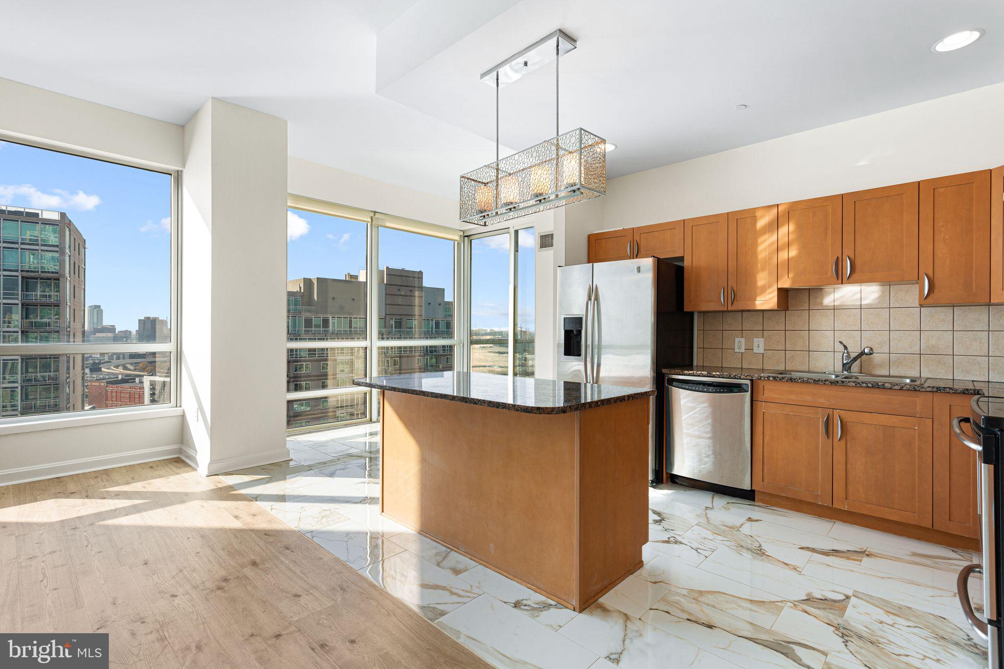 901 North Penn Street, Unit R2203 Philadelphia, PA 19123 - Photo 10 of 58 a kitchen with stainless steel appliances granite countertop a refrigerator a sink dishwasher a stove with wooden cabinets and floor