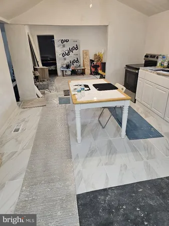 a room with table chairs and white appliances