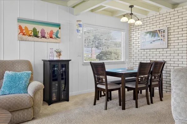 a view of a dining room with furniture a chandelier and a window