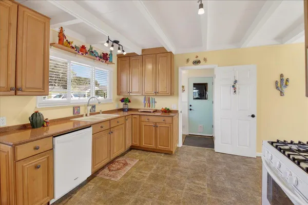 a kitchen with granite countertop a sink stove and refrigerator