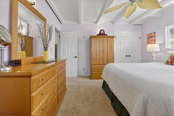 a spacious bedroom with a bed and a dresser