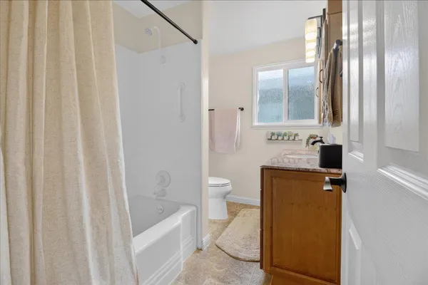 a bathroom with a granite countertop sink toilet and shower
