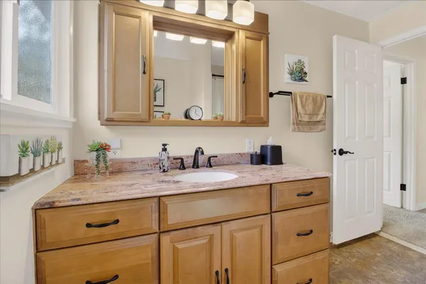 a bathroom with a granite countertop sink vanity mirror shower and