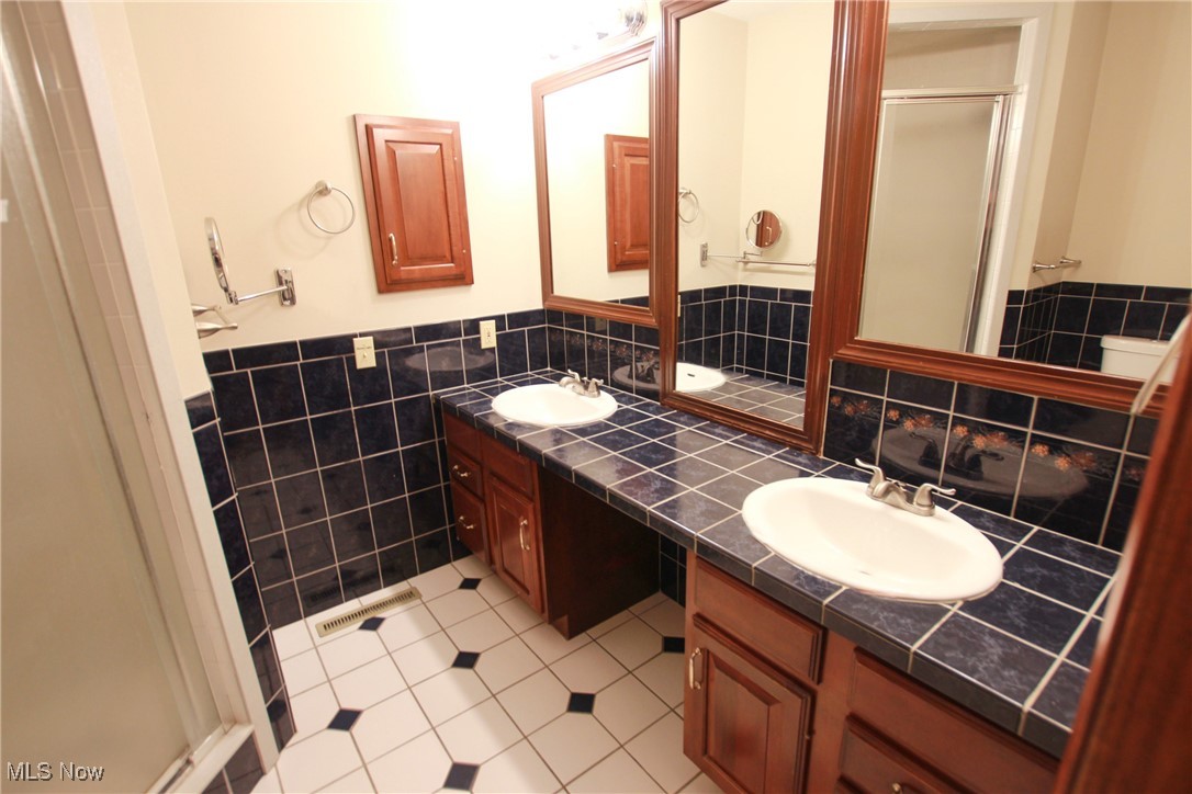 1031 Georgetown Road Salem, OH 44460 - Photo 14 of 31 Full bath featuring a stall shower, tile walls, a sink, and double vanity