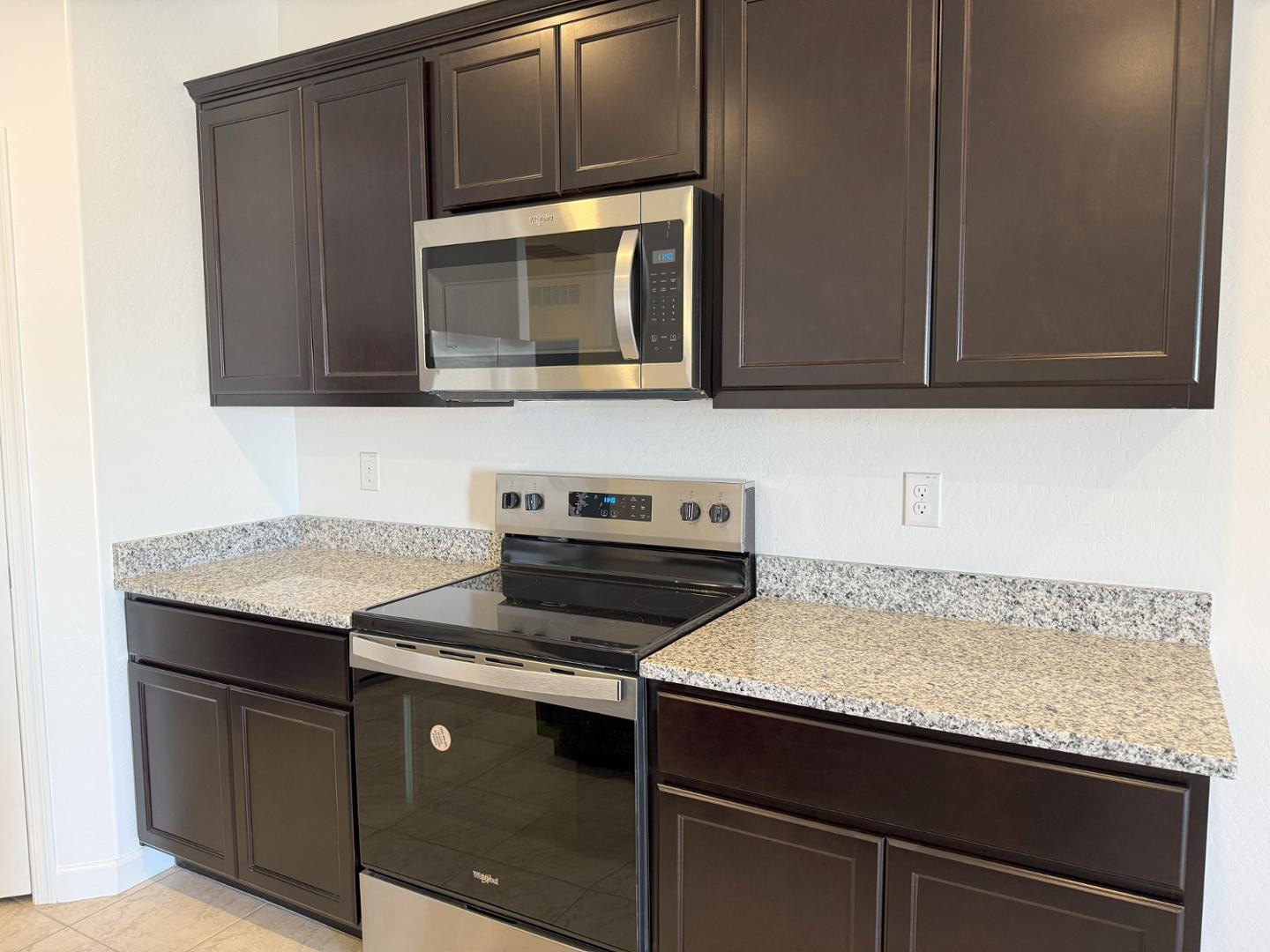 1840 West Spaulding Avenue Apache Junction, AZ 85120 - Photo 32 of 53 a kitchen with granite countertop cabinets stove and microwave