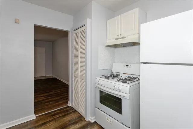 a kitchen with stove and white cabinets